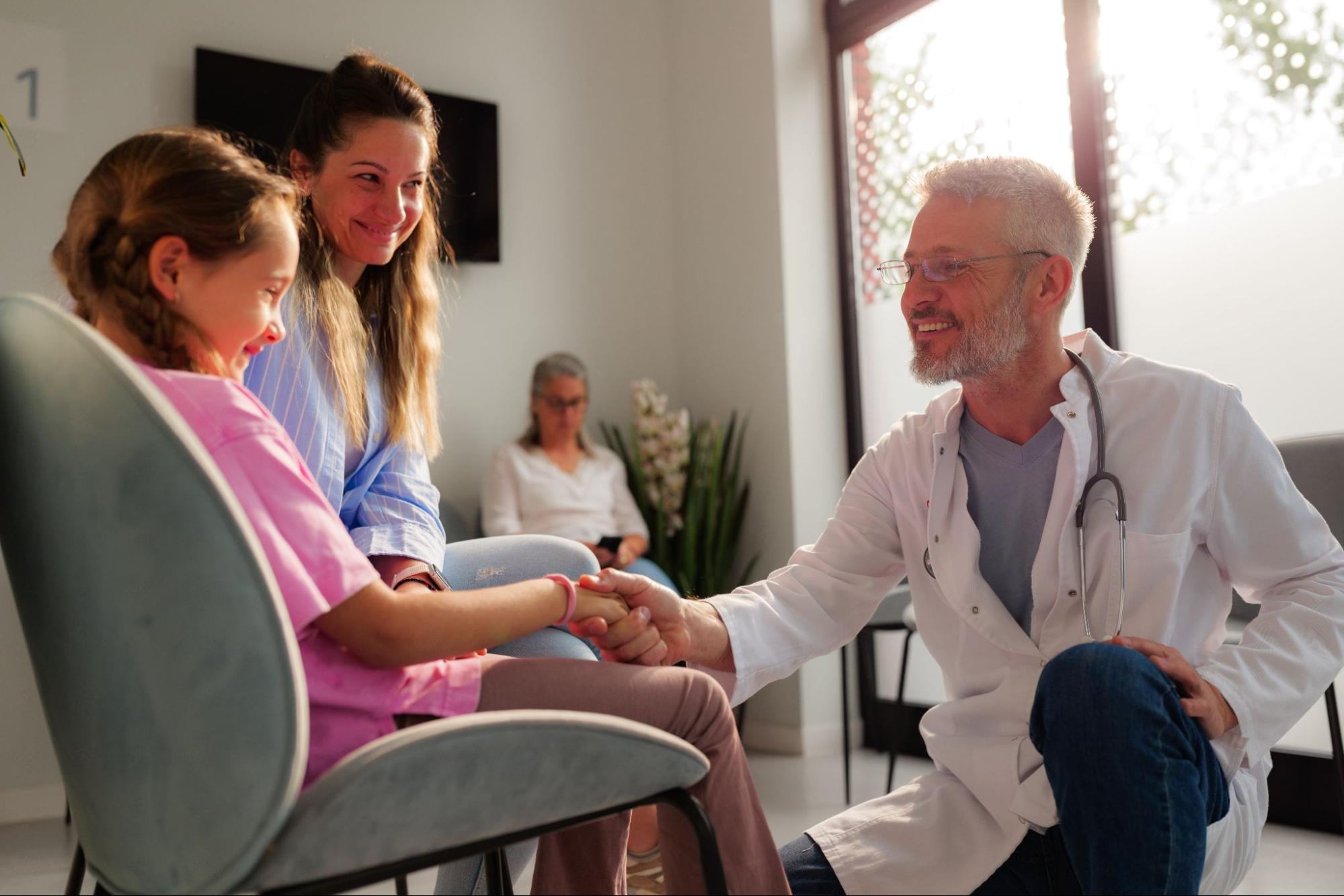 Doctor connecting with patient and mother at an appointment.